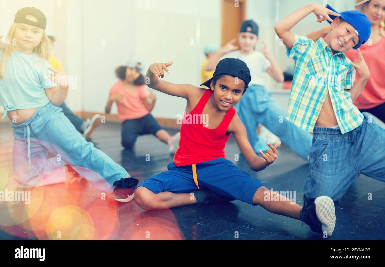 Gruppo multietnico di bambini in abbigliamento casual allenarsi movimenti  hip hop in classe di danza con allenatore femminile Foto stock - Alamy