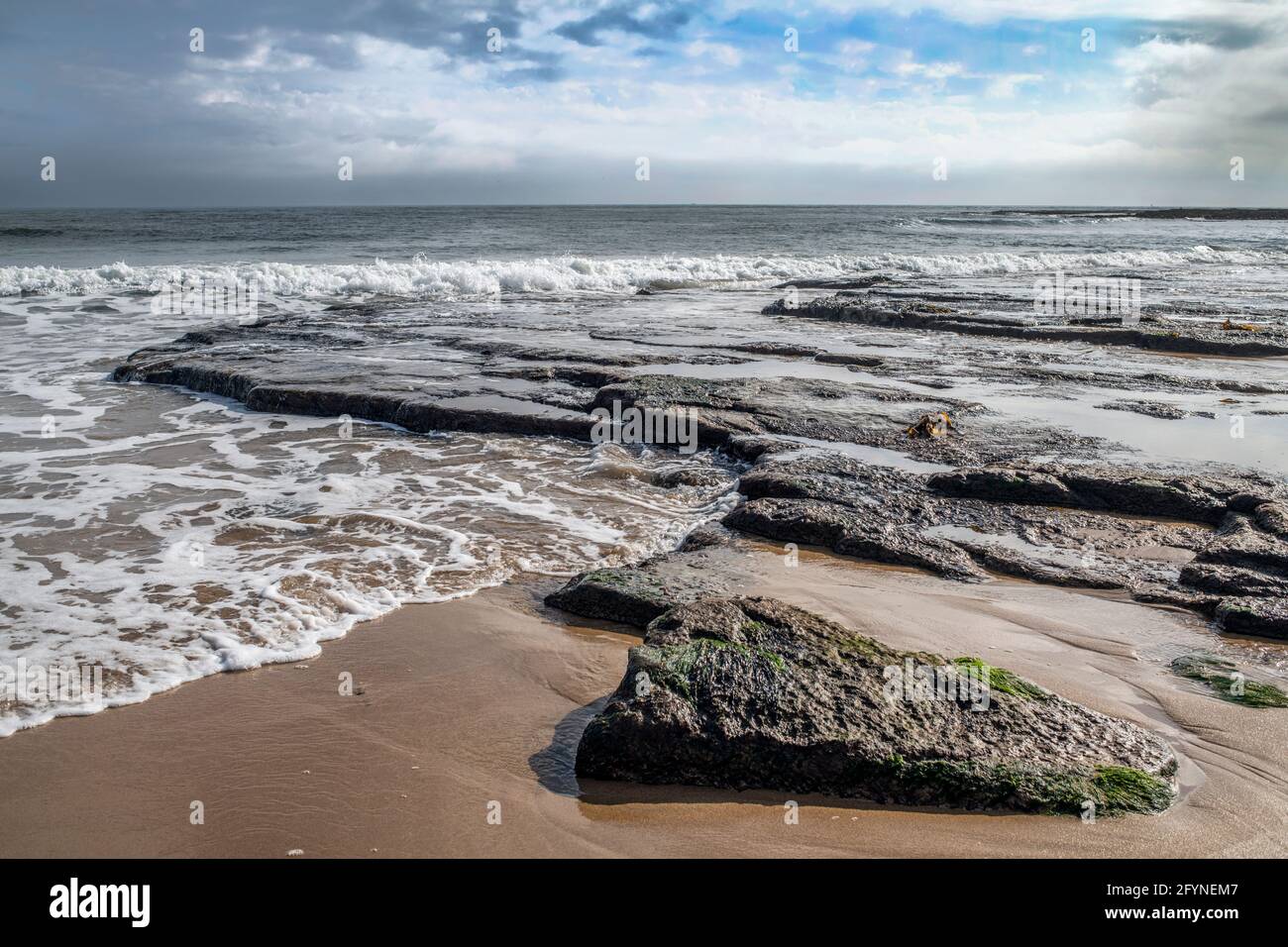 Nuvole di pioggia che iniziano a costruire sulla spiaggia di Northumberland Embleton Foto Stock