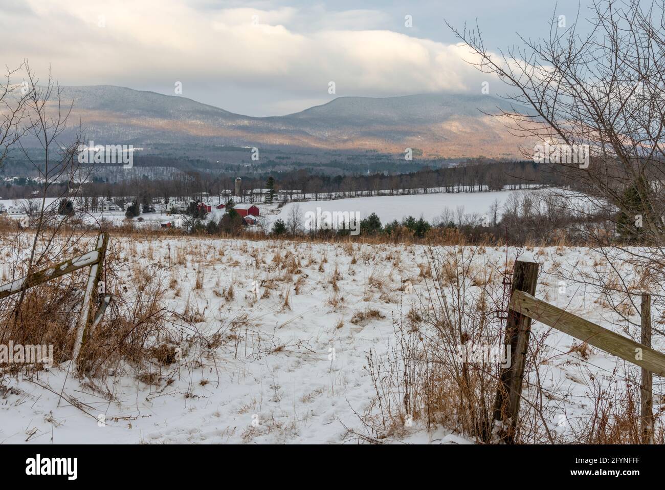 Scena mattutina di un campo innevato con un silo in lontananza e vista delle montagne Taconic sullo sfondo da Manchester, Vermont. Foto Stock