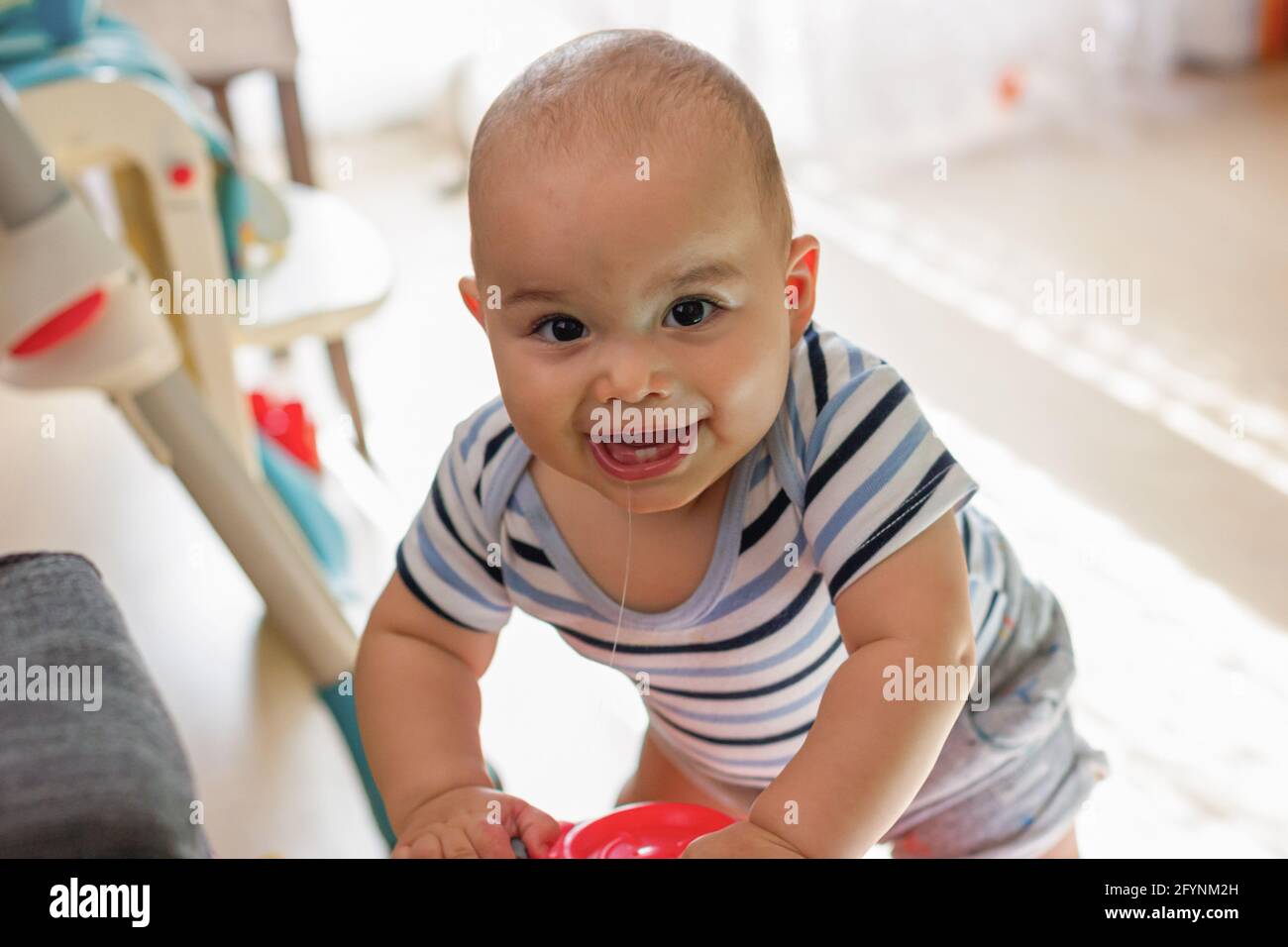 Bambino ragazzo sorridente felice che gioca con i giocattoli. Babyface primo piano Foto Stock