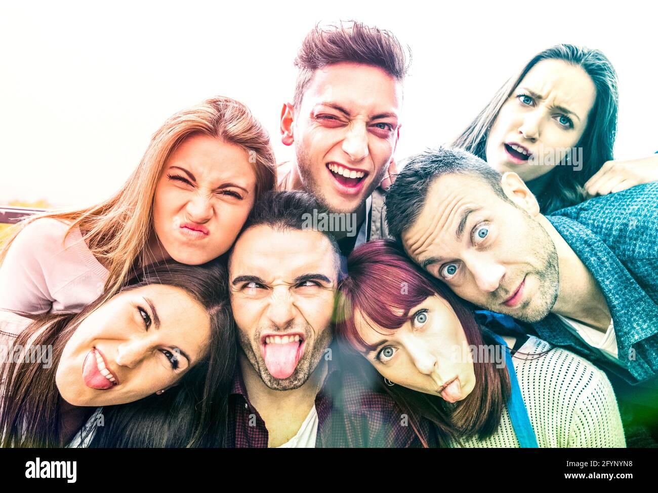 Amici milleniali multiculturali che prendono selfie con volti divertenti - concetto di amicizia felice dei giovani con giovani millenari trendy gente che si diverte Foto Stock