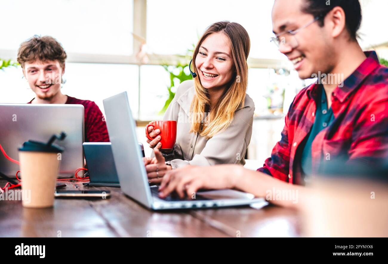 Giovani collaboratori occupati al computer in studio di startup - risorse umane e concetto di lavoro di squadra sull'orario di lavoro dei notebook Foto Stock