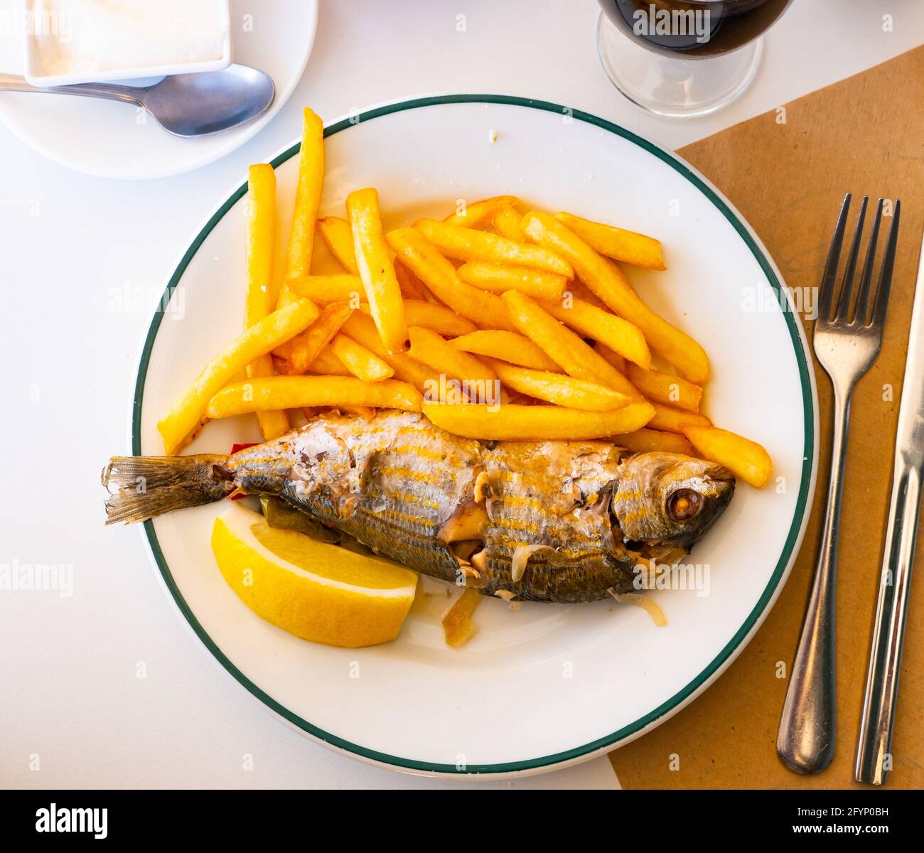 Pesce salpa fritto con patate e limone primo piano su un piatto Foto stock  - Alamy