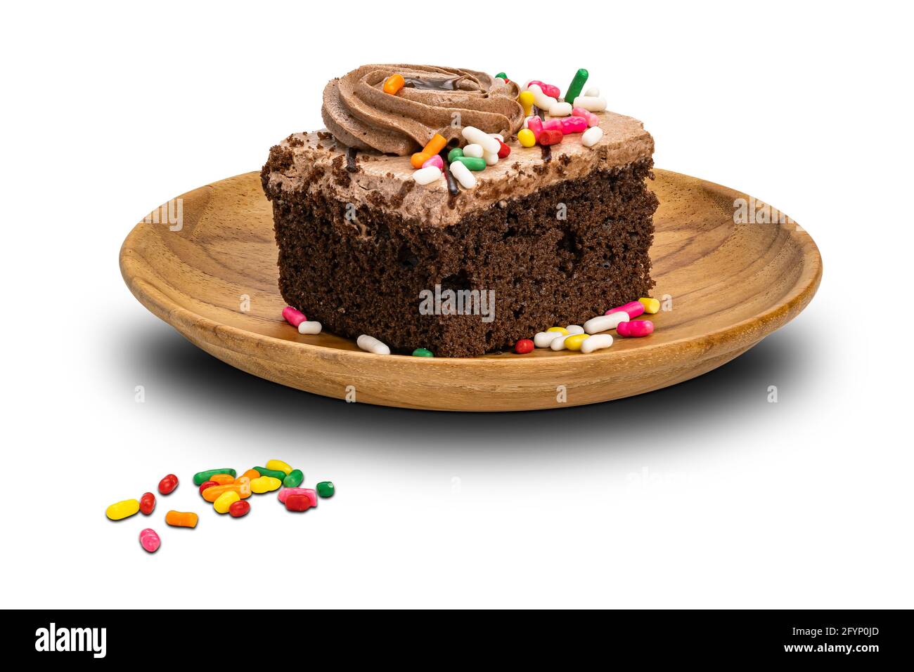 Rainbow spruzzi la guarnizione su panna torta di spugna di cioccolato in piastra di legno isolata su sfondo bianco con percorso di ritaglio. Foto Stock