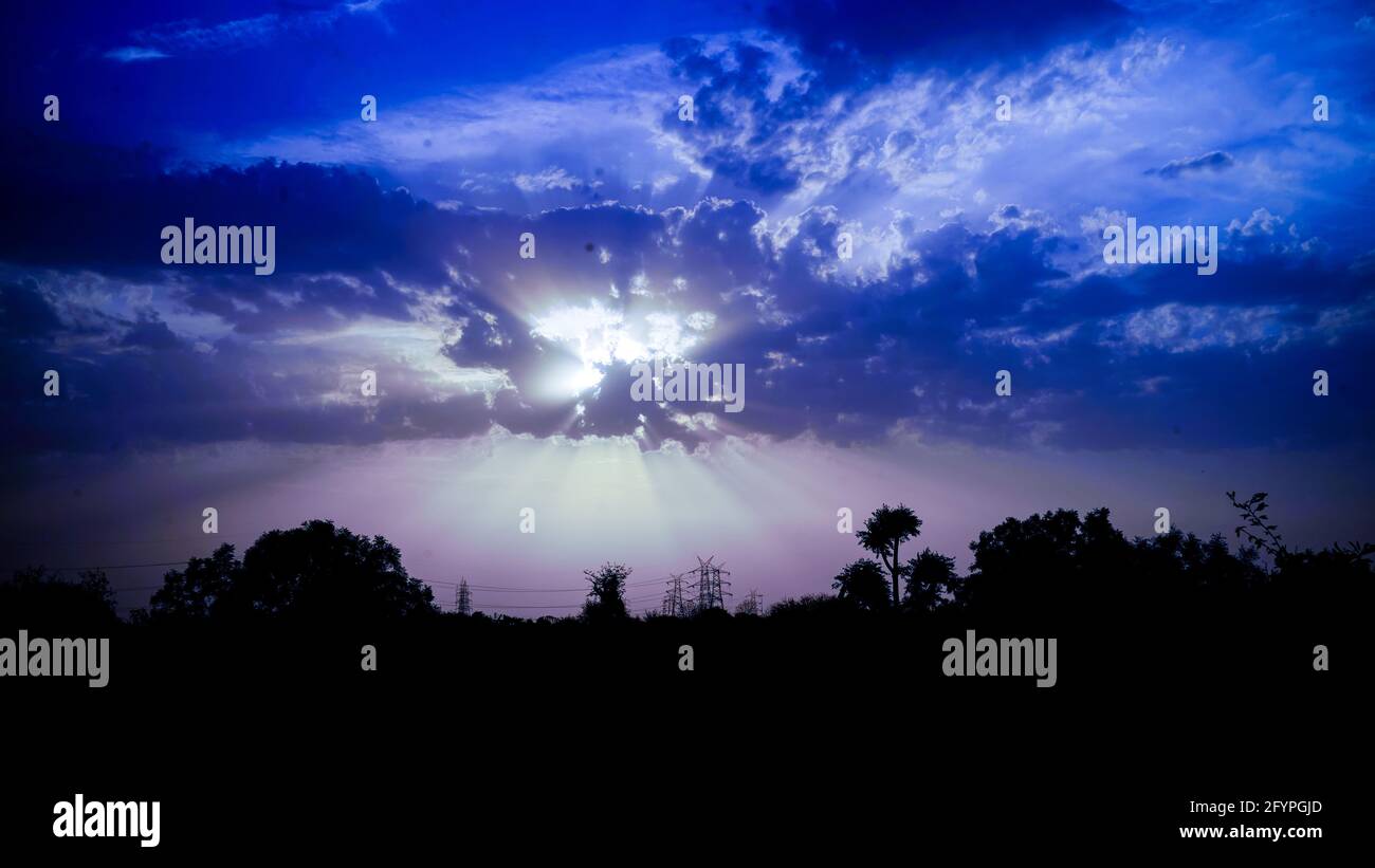 Incredibile vista del tramonto con il cielo spettacolare e le nuvole colorate. Viola con tramonto arancione in cielo blu con raggi di sole luce. Foto Stock