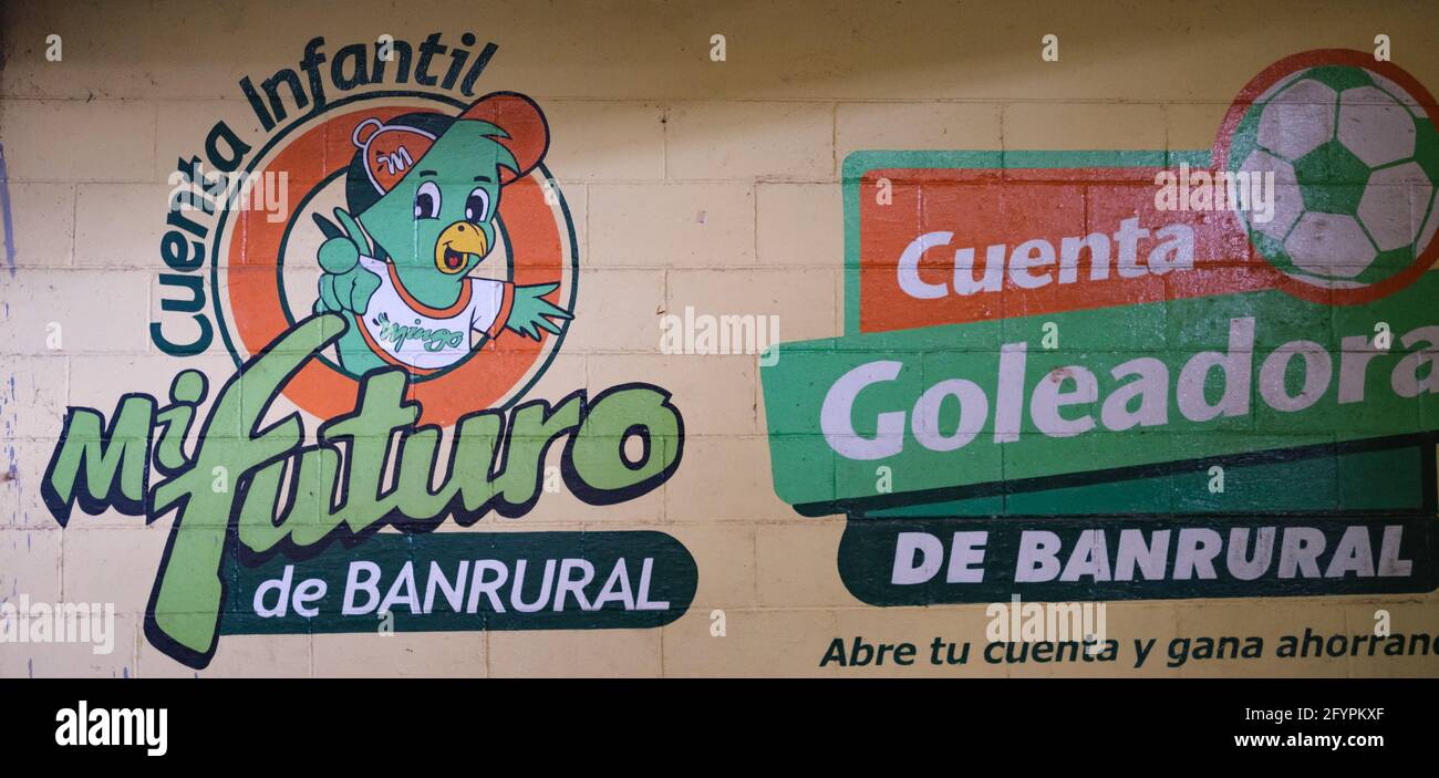 Pubblicità all'interno del mercato principale di Antigua Guatemala, per la banca Banrurale, che si rivolge ai bambini Foto Stock