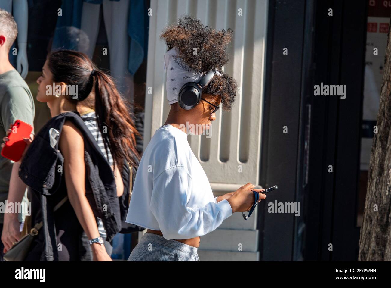 Oxford Street fine settimana di shopping alla fine di maggio AS Il sole finalmente splende e mette in luce la folla ragazza Con capelli grandi e telefono immagine di Gavin Foto Stock