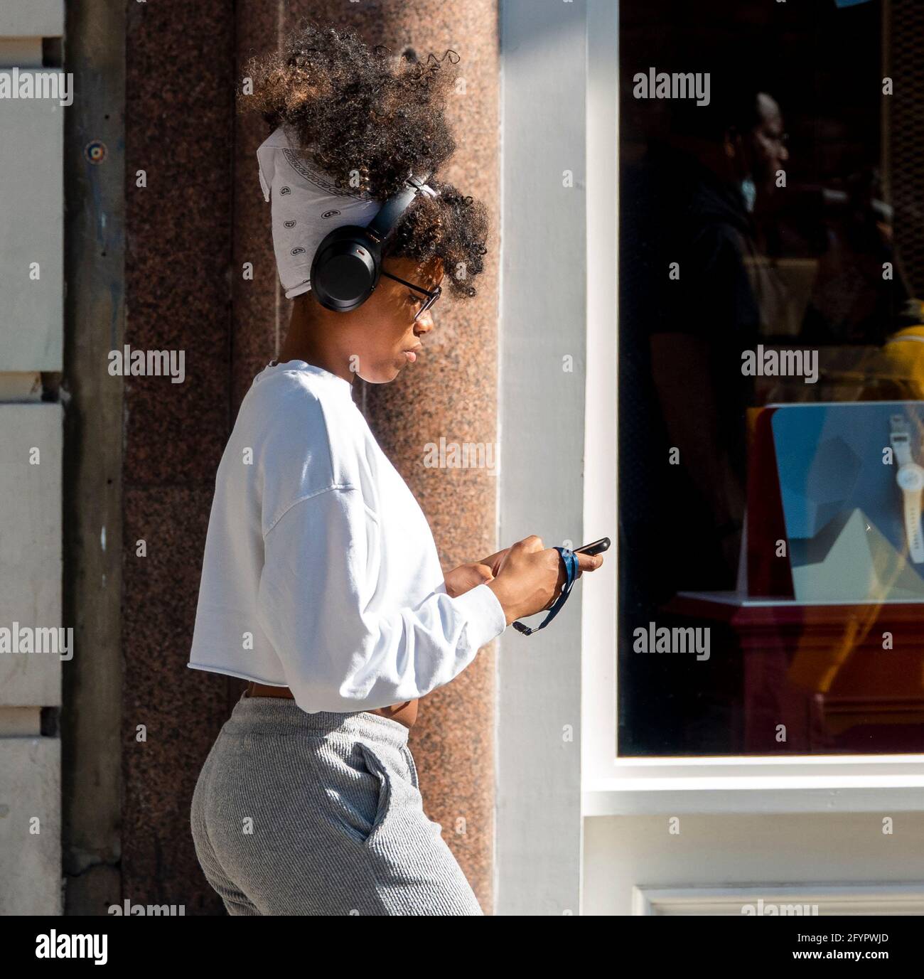 Oxford Street fine settimana di shopping alla fine di maggio AS Il sole finalmente splende e mette in luce la folla ragazza Con capelli grandi e telefono immagine di Gavin Foto Stock