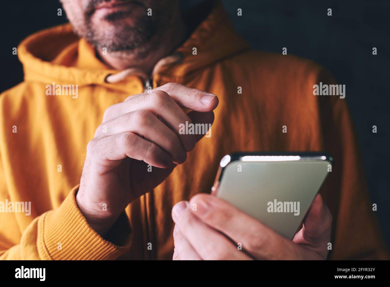 Uomo occasionale che digita un messaggio di testo sul telefono cellulare, comunicazione e concetto di connettività, primo piano con la messa a fuoco selettiva Foto Stock