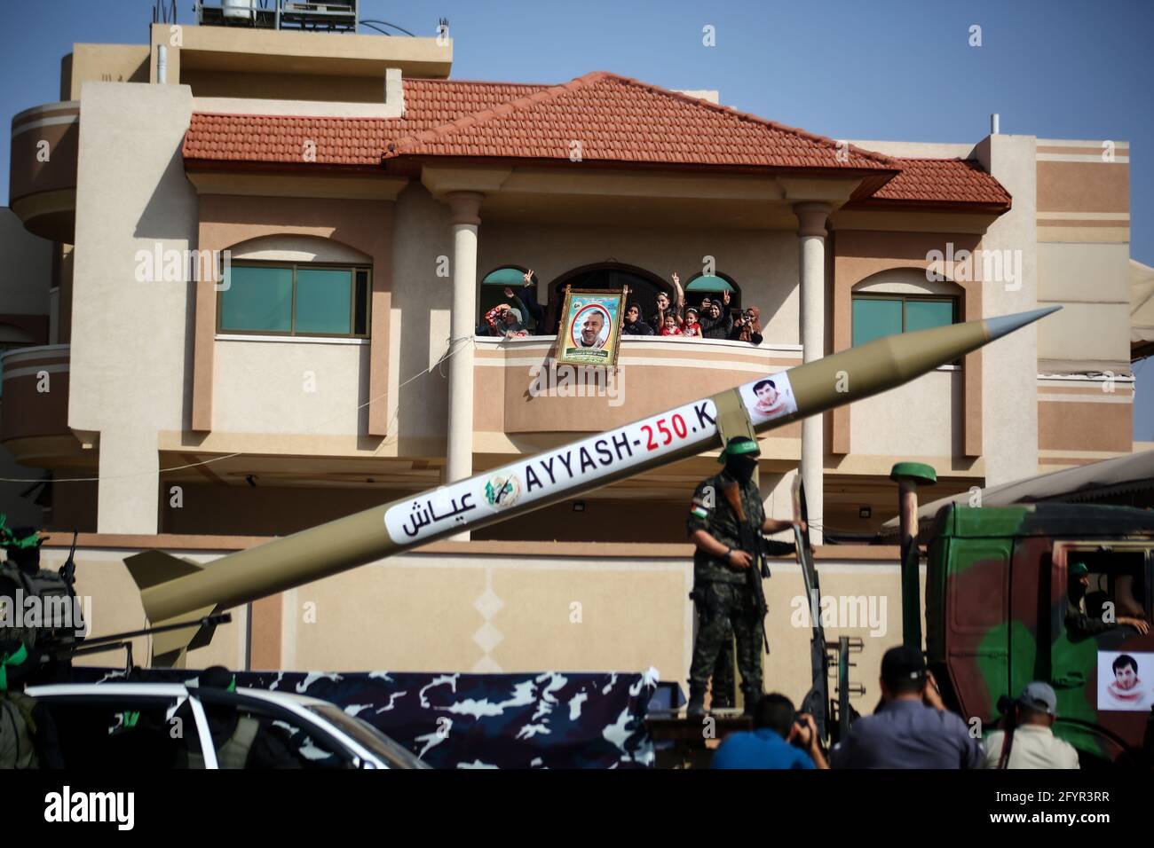 Gaza, Palestina. 29 maggio 2021. Attivisti mascherati delle Brigate Izz al-DIN al-Qassam che mostrano missili a lungo raggio, mentre la gente guarda durante una parata militare anti-Israele a Rafah, nella striscia di Gaza meridionale. Credit: SOPA Images Limited/Alamy Live News Foto Stock