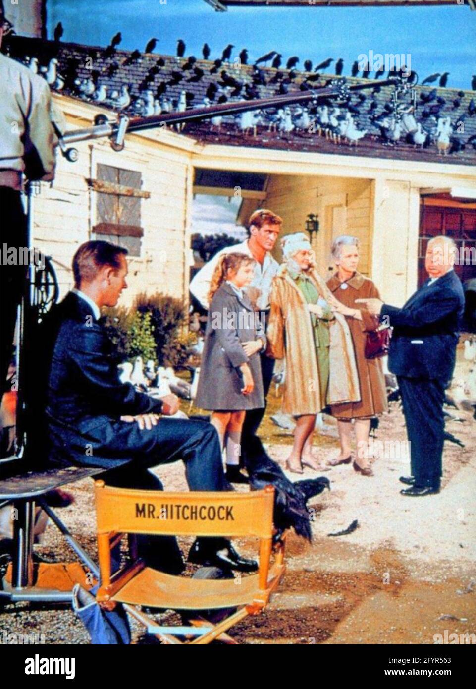 ALFRED HITCHCOCK (1899-1980 produttore di film inglese, regista e sceneggiatore sul set del suo film di Universal Pictures 'The Birds' del 1963 con Rod Taylor in camicia bianca e Tippi Hedren in pelliccia Foto Stock