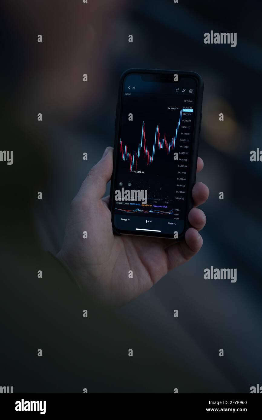 Commerciante di uomini d'affari che guarda i dati del mercato azionario sullo schermo dello smartphone e l'analisi del grafico forex Foto Stock