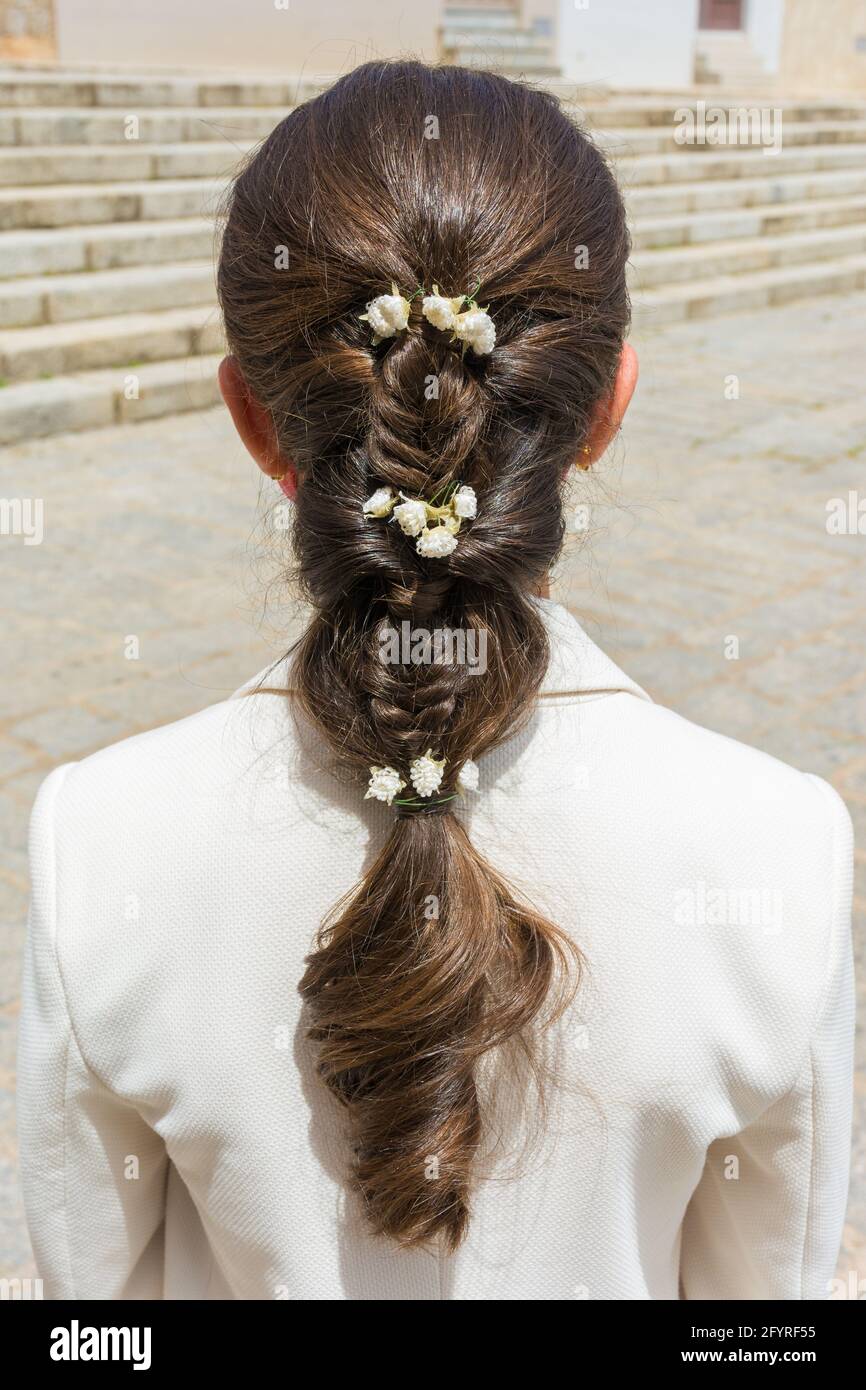 Treccia (treccia) decorata con fiori piccoli per un matrimonio Foto Stock