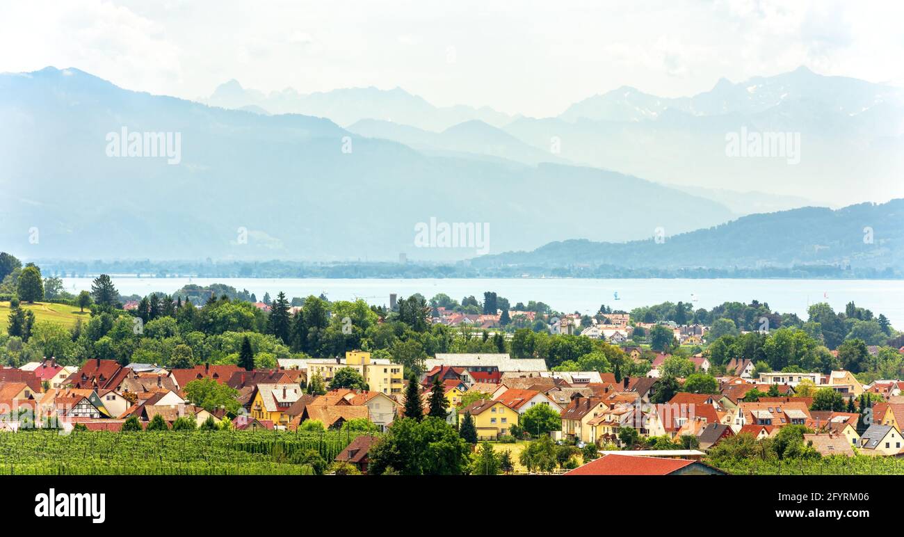 Paesaggio con Bodensee o lago di Costanza, Baviera, Germania. Panorama di piccola città che domina le Alpi svizzere in estate. Vista panoramica del villaggio tedesco An Foto Stock