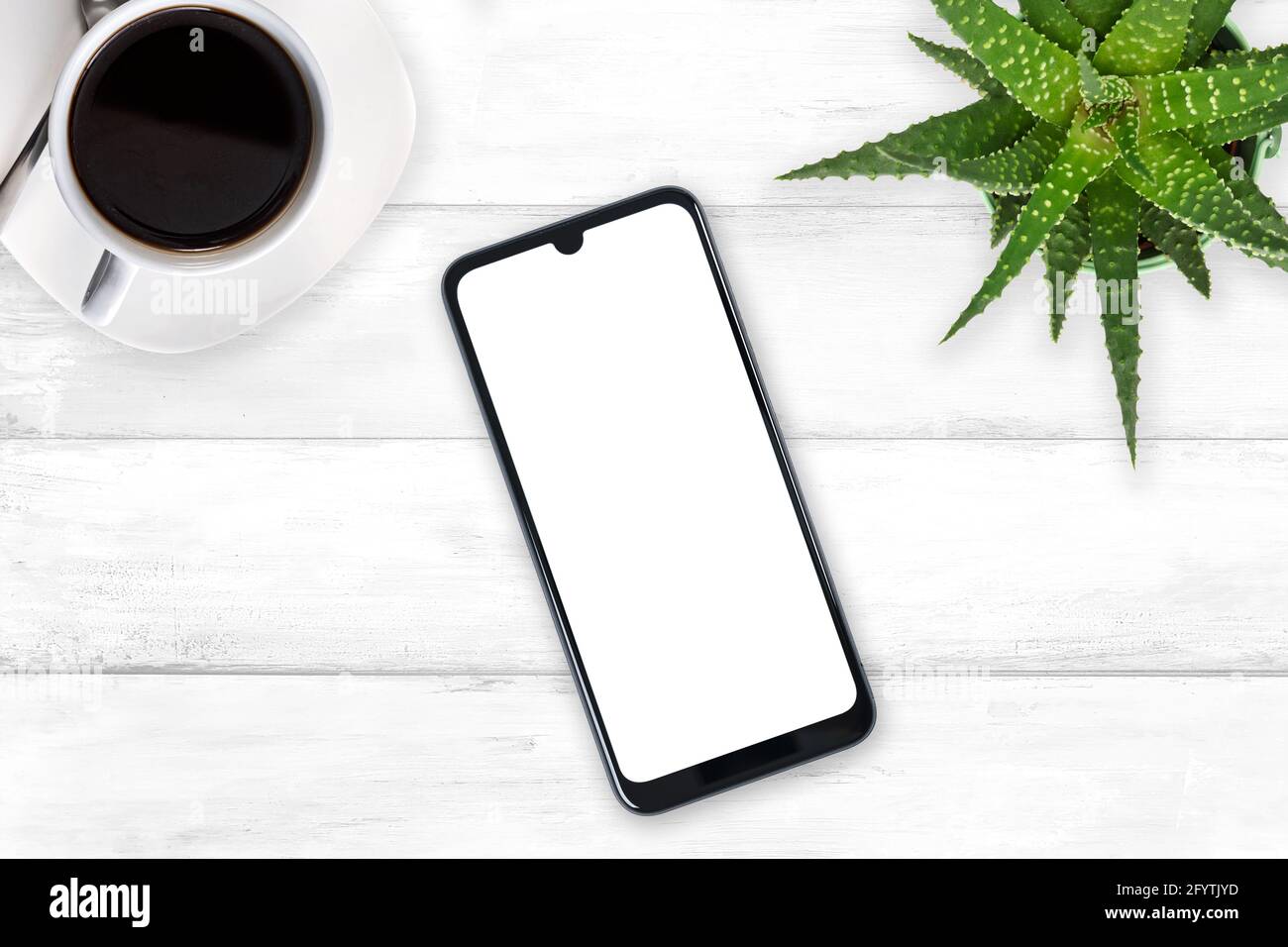 Vista dall'alto di un nuovo moderno mockup smartphone con spazio vuoto schermo bianco su un tavolo di legno vintage con caffè e. fiore verde (spazio copia) Foto Stock