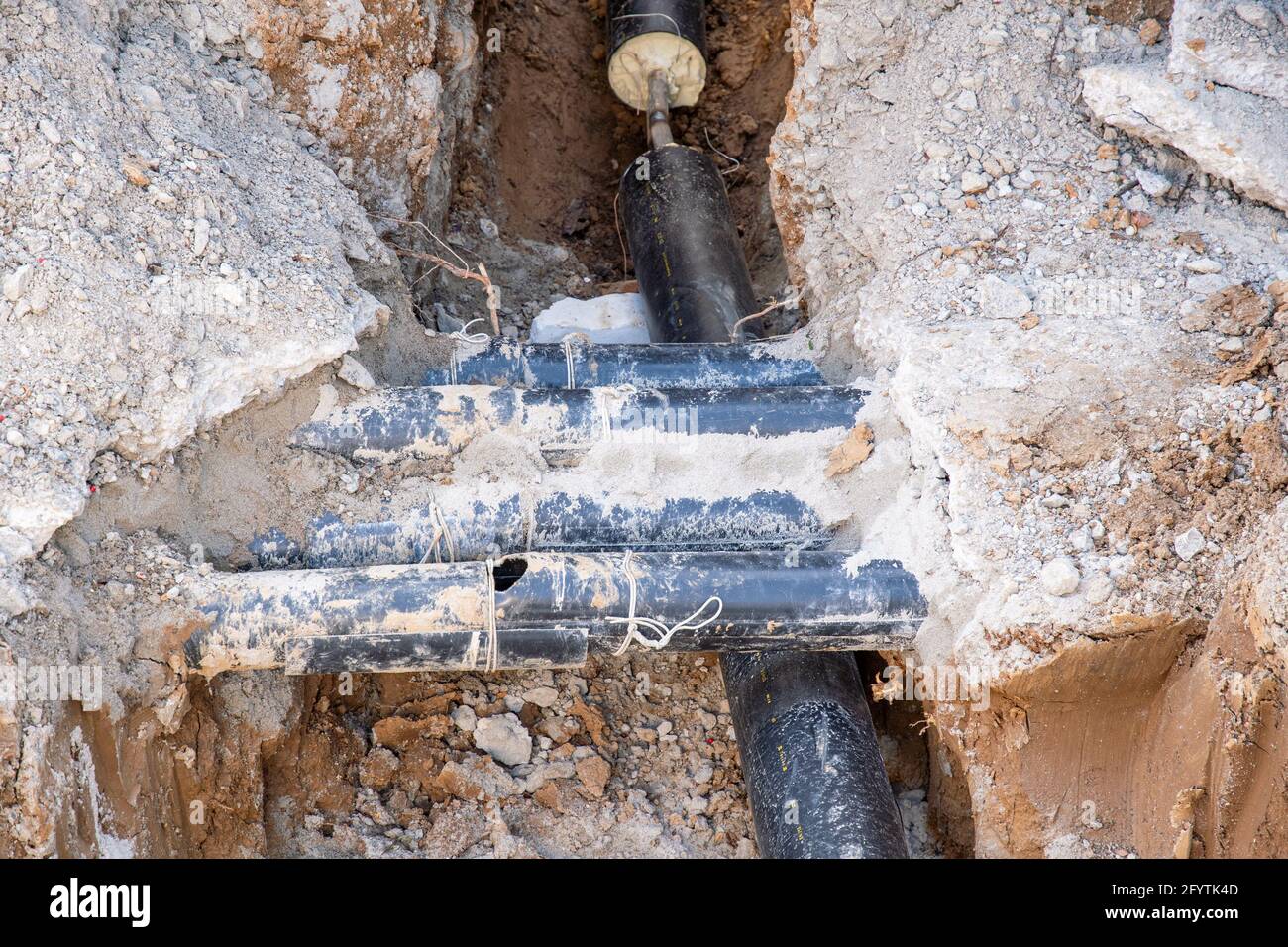 Un gruppo di tubi di riscaldamento disposti in tubi di plastica neri sul cantiere Foto Stock