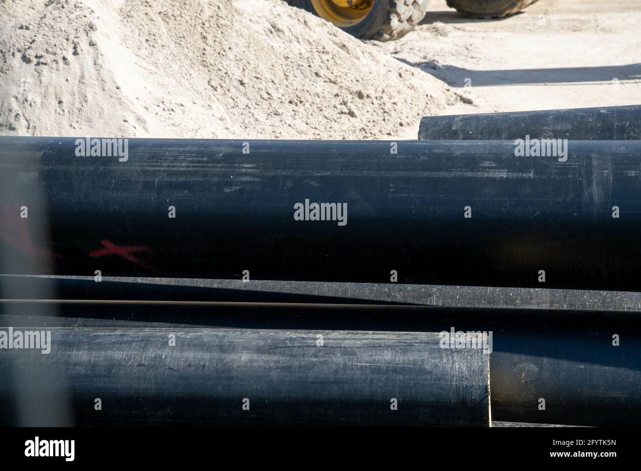Un lotto di tubi di plastica neri nell'area di costruzione Foto Stock