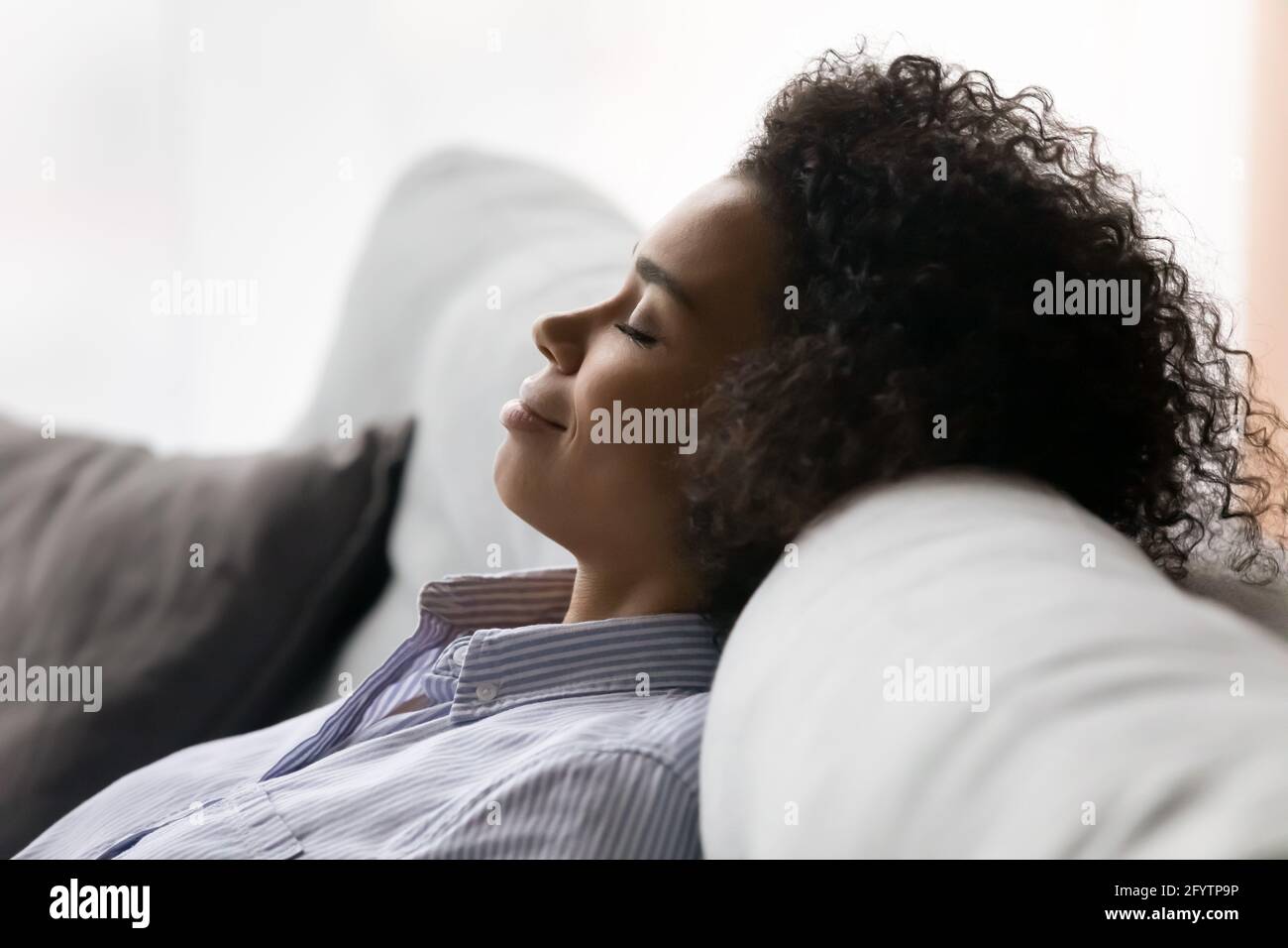 Primo piano di donna biraciale relax dormire sul divano Foto Stock