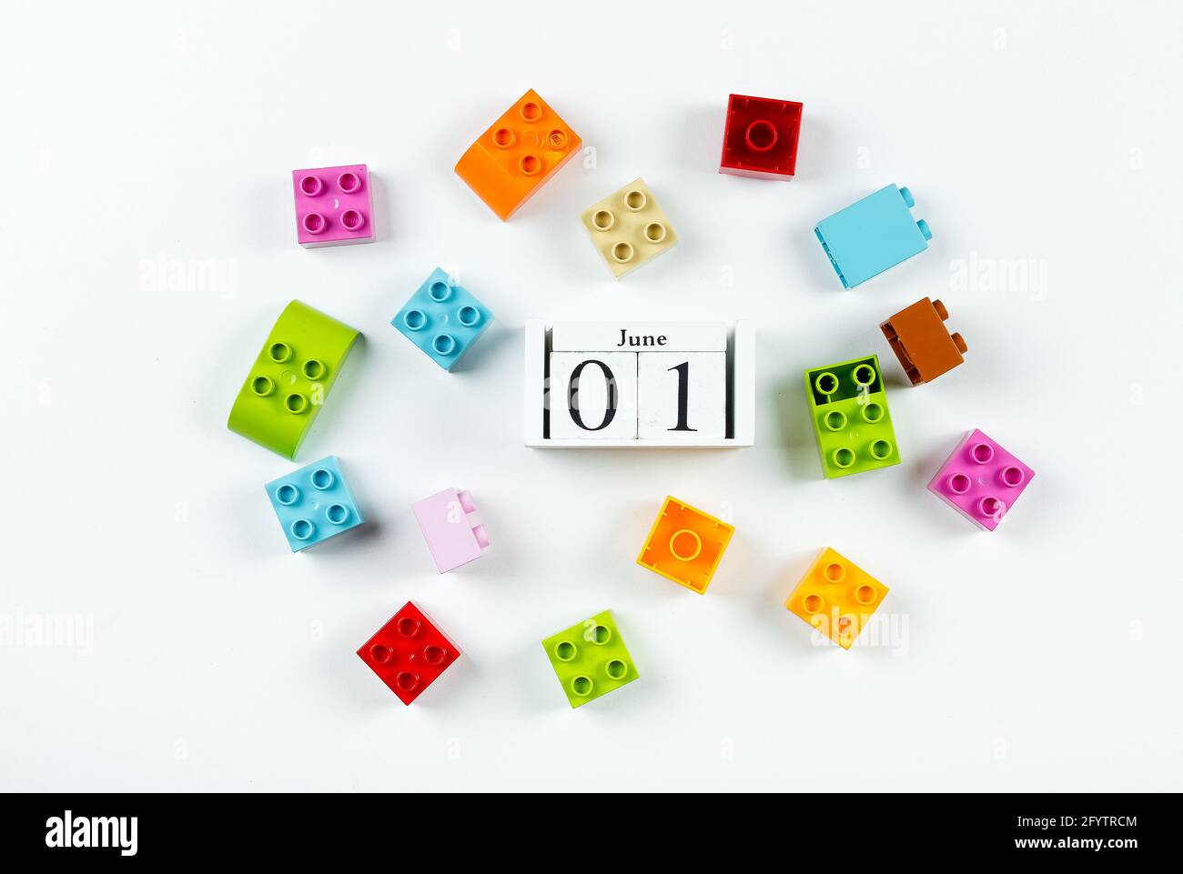 Buon giorno per i bambini. Cubi di legno data calendario 1 giugno e cubi colorati di plastica su sfondo bianco. Modello di posa piatta Creative Top View Foto Stock