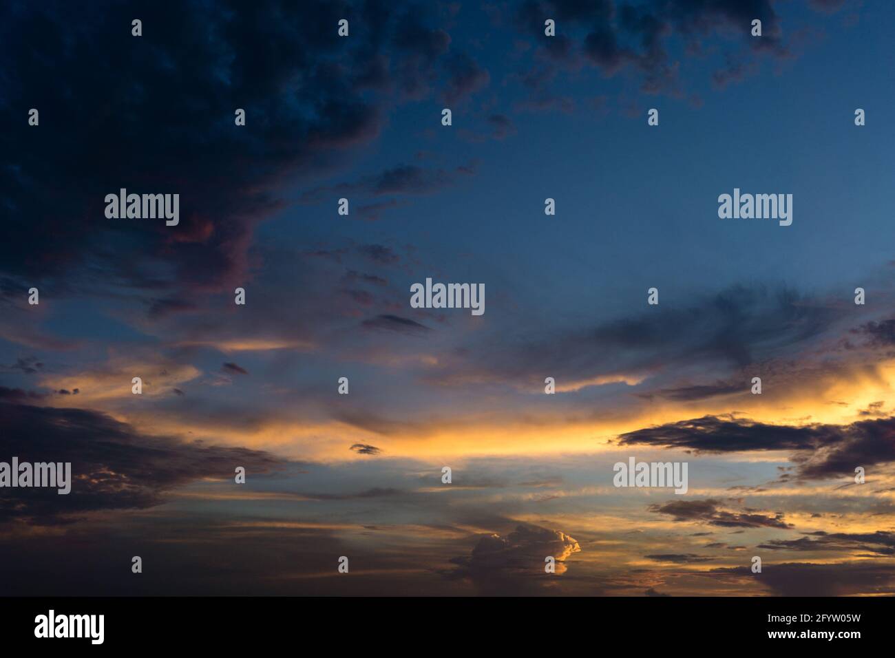 Un ampio angolo di un cielo serale con nuvole colorate. L'ora d'oro. Foto Stock