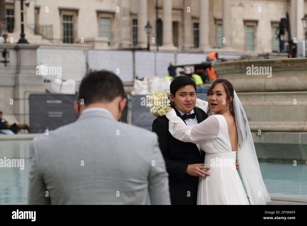 Una coppia asiatica ha le loro foto di nozze scattate in Trafalgar Square, Londra, Regno Unito Foto Stock