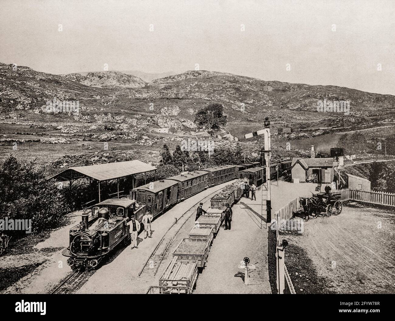 Una vista del tardo 19 ° secolo della stazione di Tan-y-bwlch sulla Ffestiniog Railway, una ferrovia a scartamento ridotto, costruita nel 1860 e situata a Gwynedd, Galles. Lunga circa 13.5 km (21.7 miglia), corre su un'unica pista con quattro posti intermedi di passaggio, dal porto di Porthmadog alla città mineraria dell'ardesia di Blaenau Ffestiniog. Fu costruito per facilitare il movimento di ardesia dalle cave di ardesia di Blenau Ffestiniog. Foto Stock