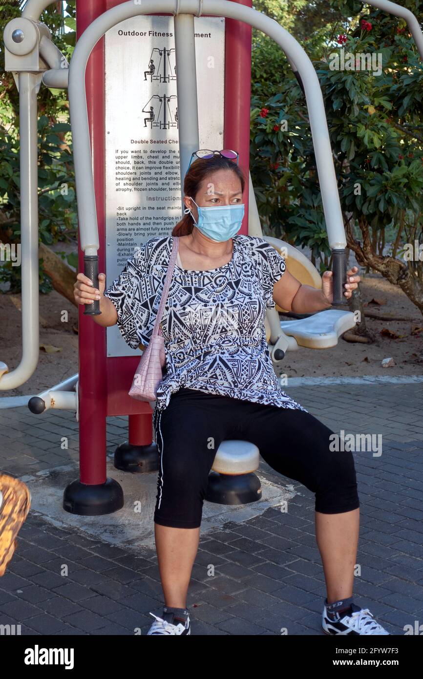 Esercizio di COVID. Persone che si allenano durante il covid all'aperto, utilizzando attrezzature per la comunità, indossando maschere facciali Thailandia Sud-est asiatico Foto Stock