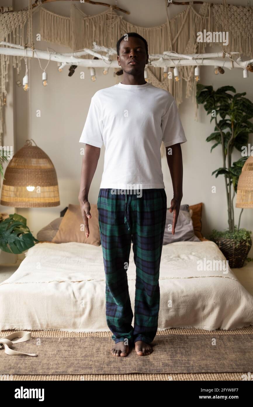 Uomo africano che lavora fuori, yoga, pilates, addestramento di idoneità, asana di base in piedi tadeasana, postura di yoga di montagna Foto Stock