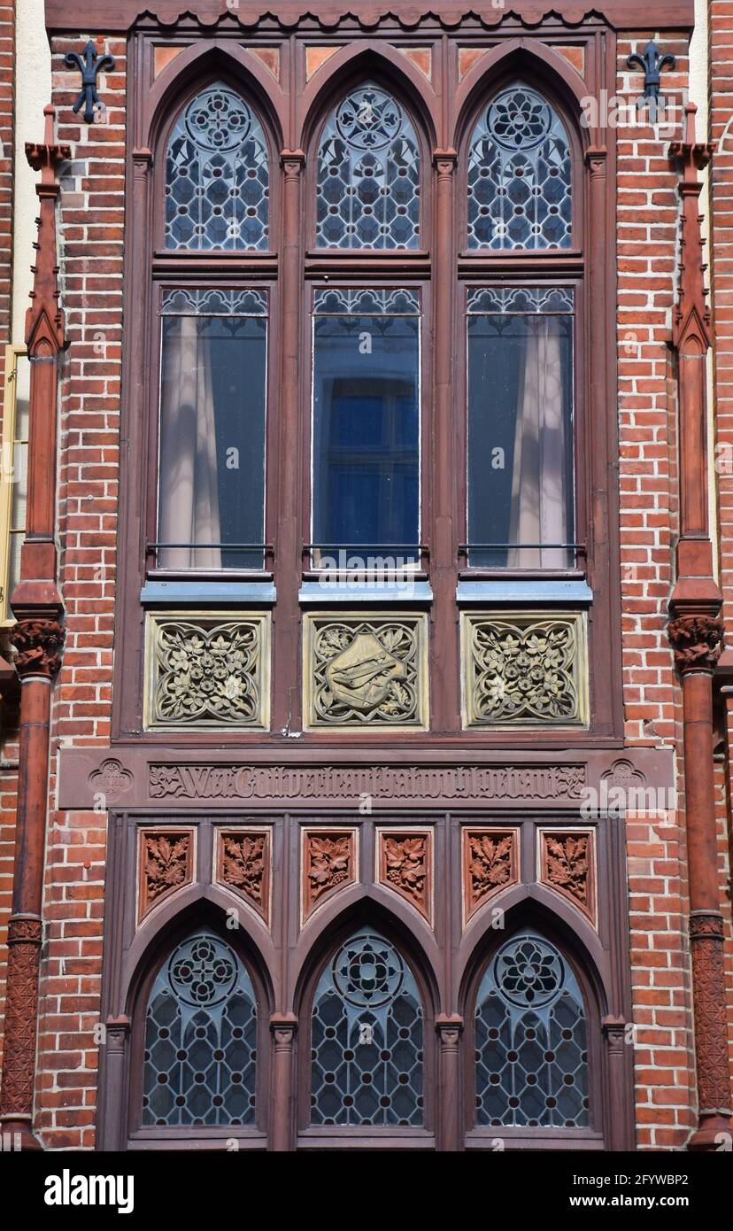 Antica facciata in mattoni rossi con finestre decorate con arte a Schwerin, Germania Foto Stock