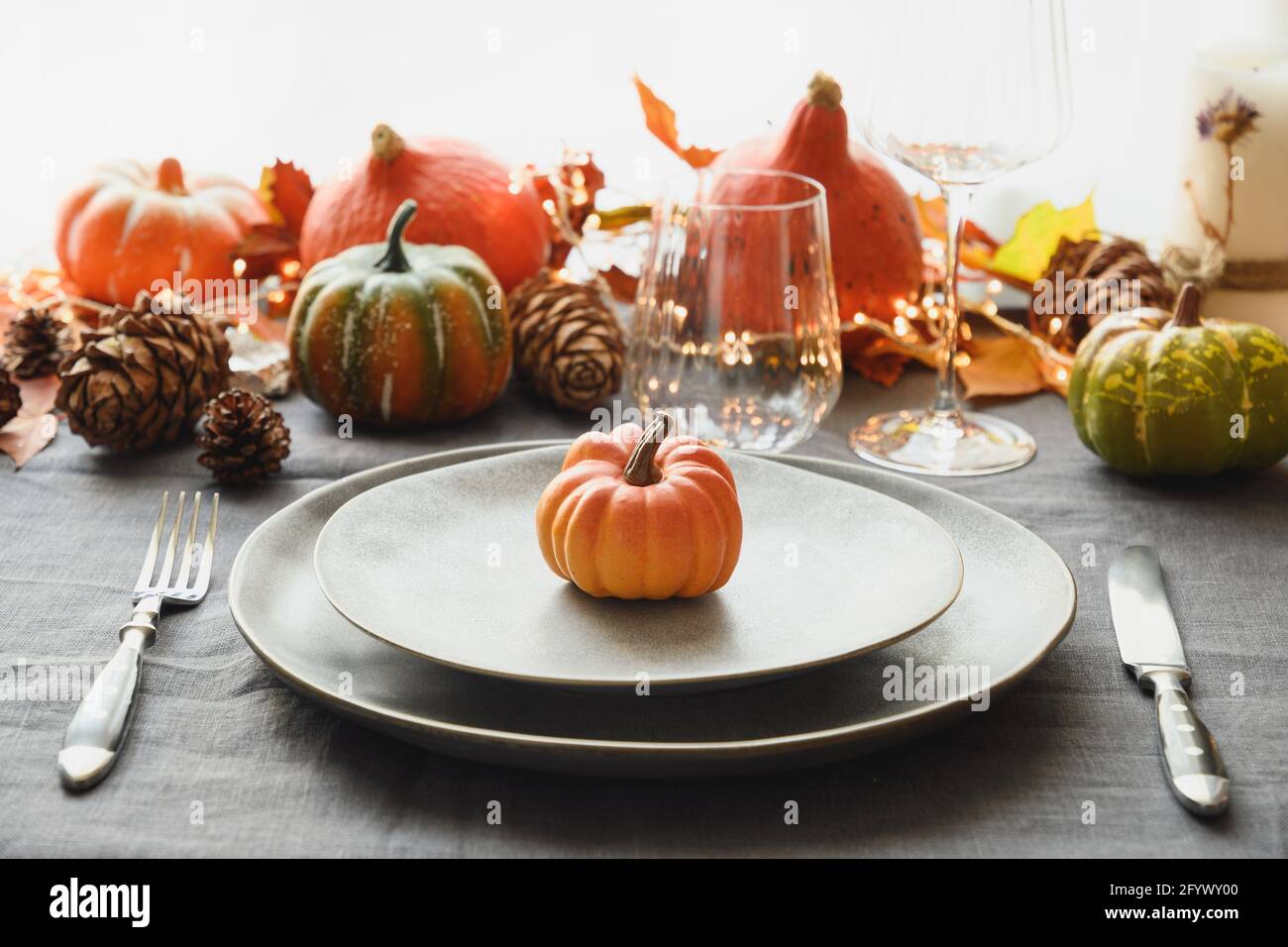 Halloween e giorno del Ringraziamento cena decorata foglie caduti, zucche, spezie, piatto grigio. Primo piano. Foto Stock