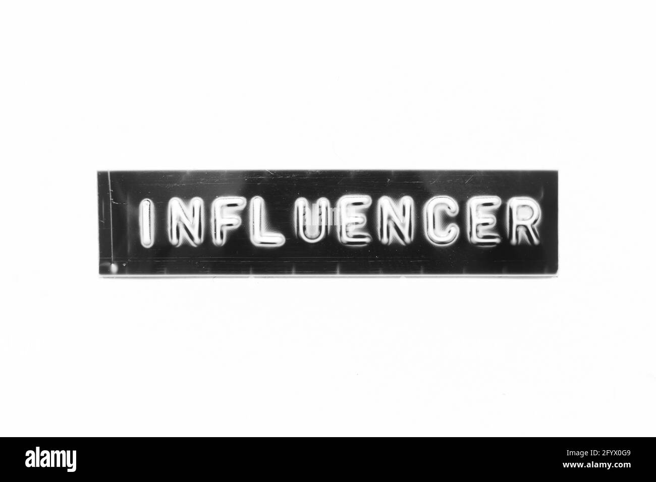 Lettera in rilievo con parola influencer in banner nero su bianco sfondo della carta Foto Stock