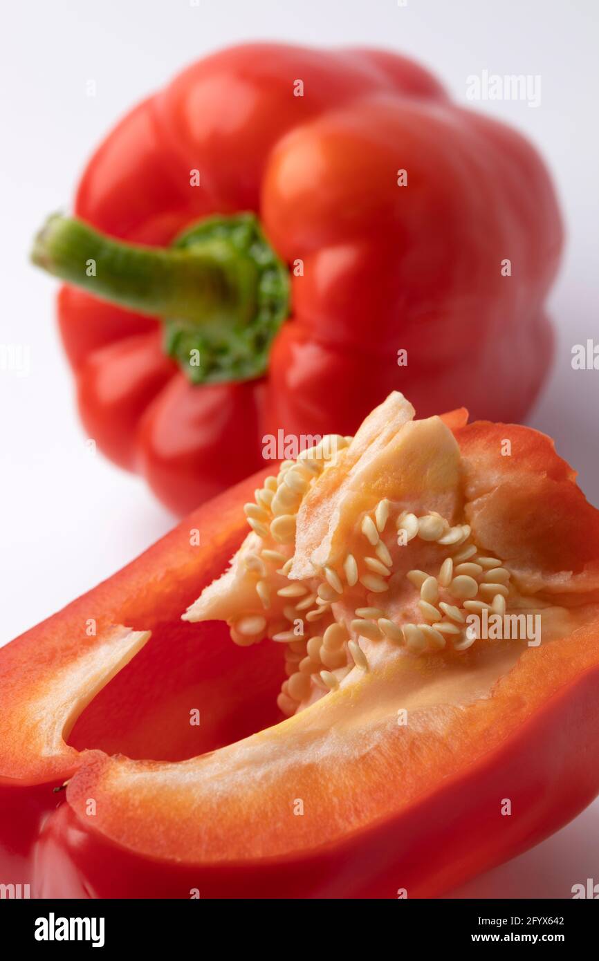 Peperone rosso dolce intero e dimezzato con semi chiusi su Foto Stock