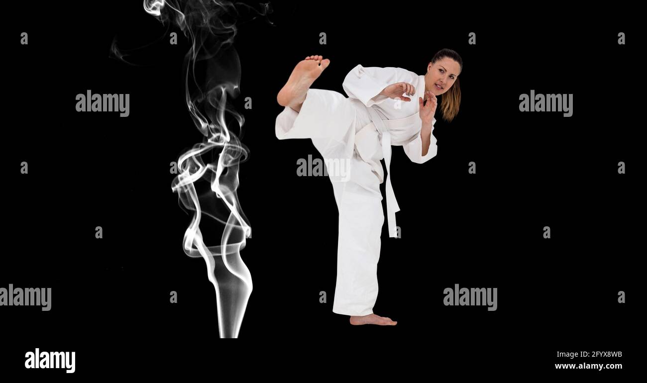 Composizione di artista di Karate marziale femminile con calci a cintura bianca sopra fumo e spazio di copia Foto Stock