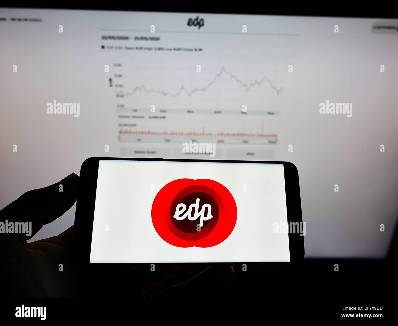 Persona che detiene smartphone con il logo della società di servizi Energias de Portugal S.A. (EDP) sullo schermo di fronte al sito web. Mettere a fuoco il display del telefono. Foto Stock