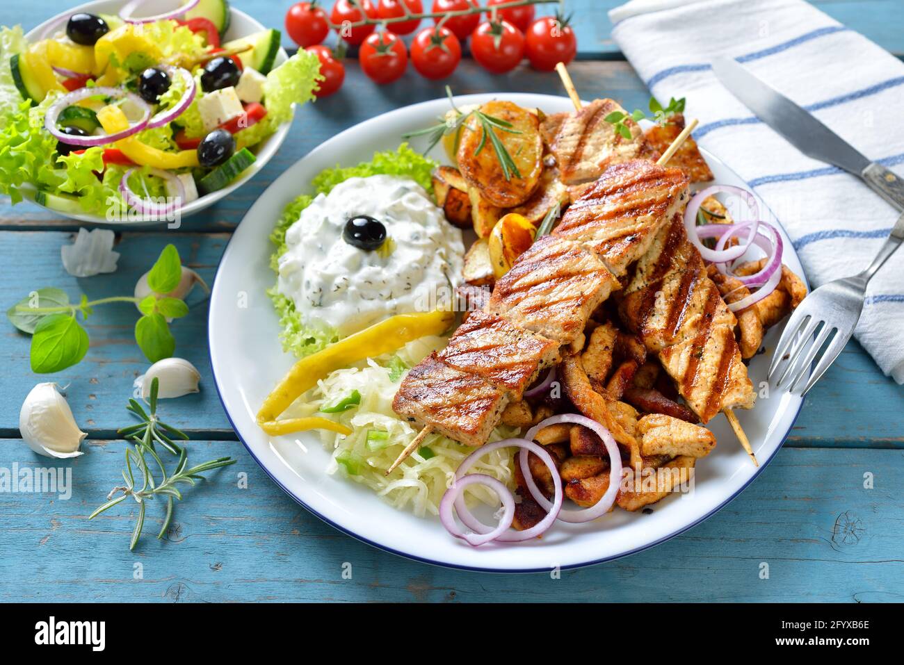 Grigliata mista greca con gyros, souflaki, tzatziki e coleslaw, servita con insalata contadina Foto Stock