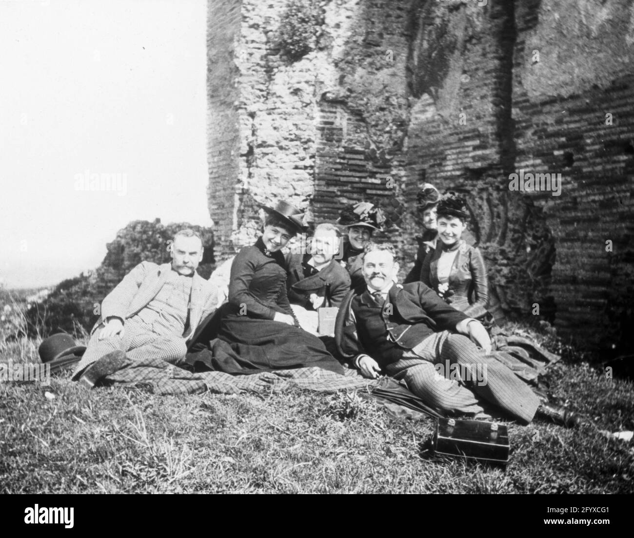 Amici maschi e femmine di viaggiatore americano, fotografo e regista Burton Holmes (1870–1958) Godetevi un picnic sull'erba lungo la Via Appia, Roma, Italia 1890. (Foto di Burton Holmes) Foto Stock