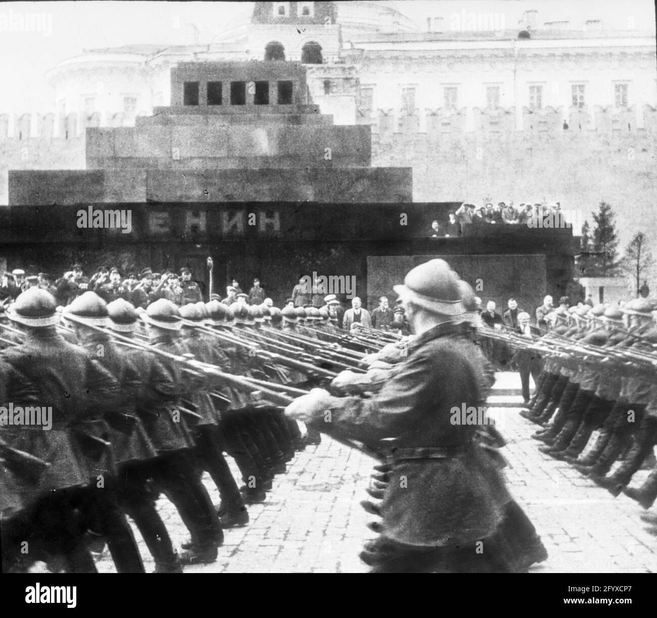 I soldati che tengono le baionette marciano oltre il Mausoleo di Lenin nella Piazza Rossa durante la sfilata del giorno di Maggio, Mosca, Russia, 1934. (Foto di Burton Holmes) Foto Stock