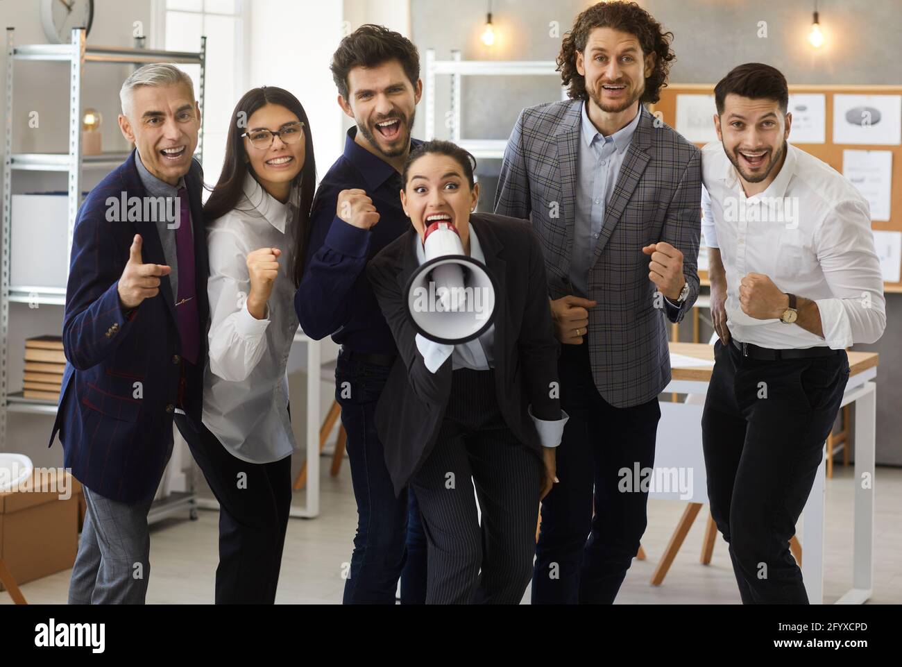 Un gruppo di persone di affari felici e dirigenti di assunzione e. urlare in un megafono Foto Stock