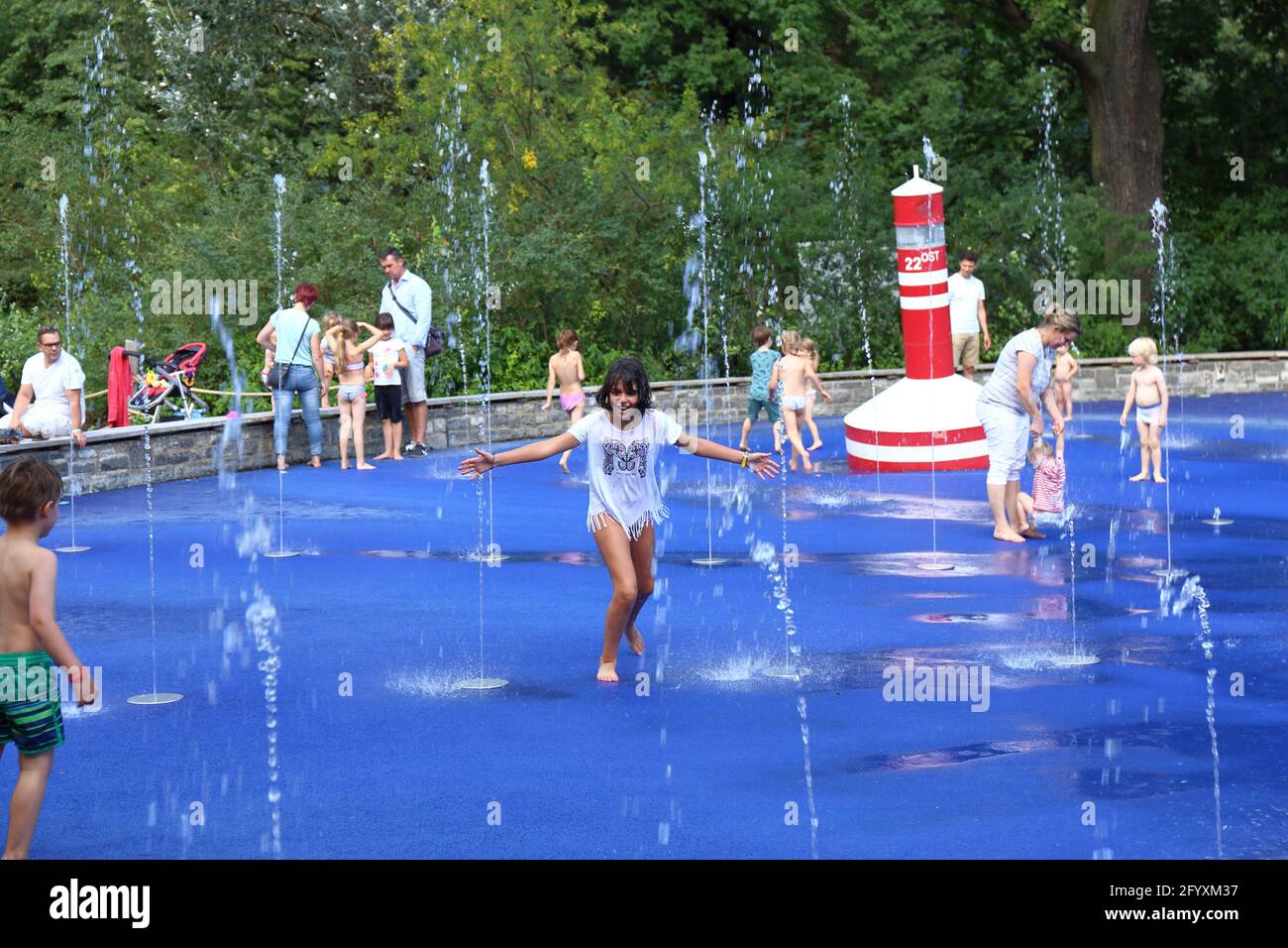 i bambini si divertono con la giornata di sole e giocano con il acqua nel parco giochi acquatico Foto Stock