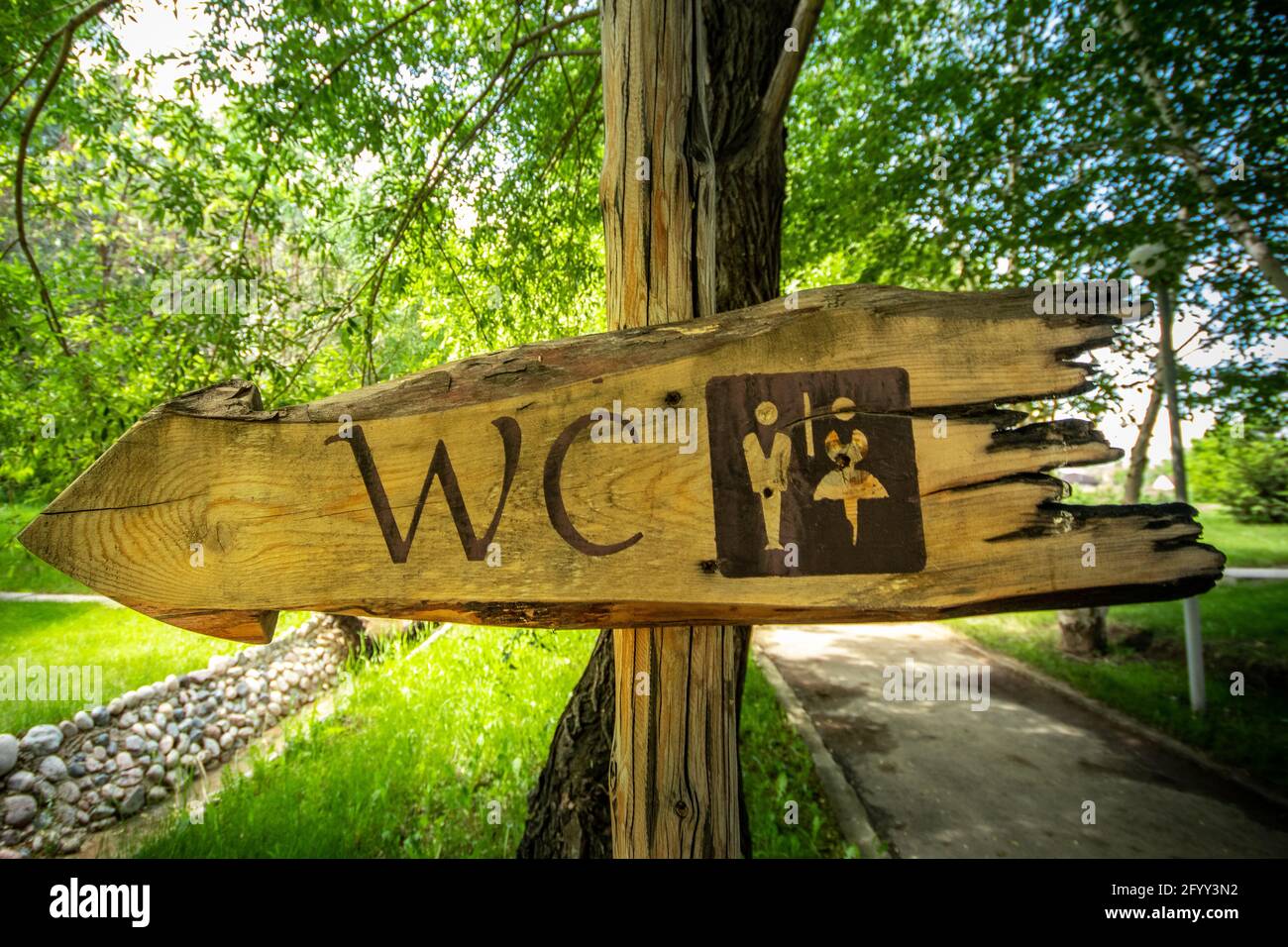 WC ligneo puntatore, segno del gabinetto nel parco. Foto Stock