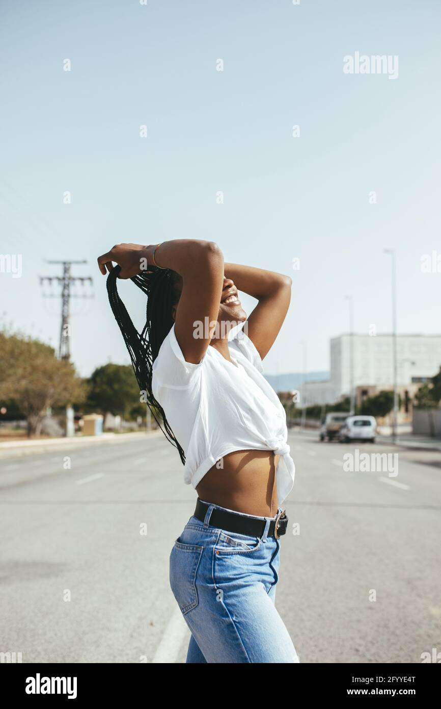 Fidata signora con chitarra che canta nel microfono mentre suona la canzone in un club luminoso con luce al neon Foto Stock