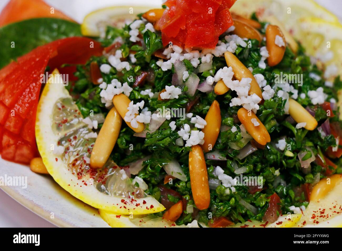 insalata di prezzemolo verde fresco con pomodori e pinoli, cibo libanese Foto Stock