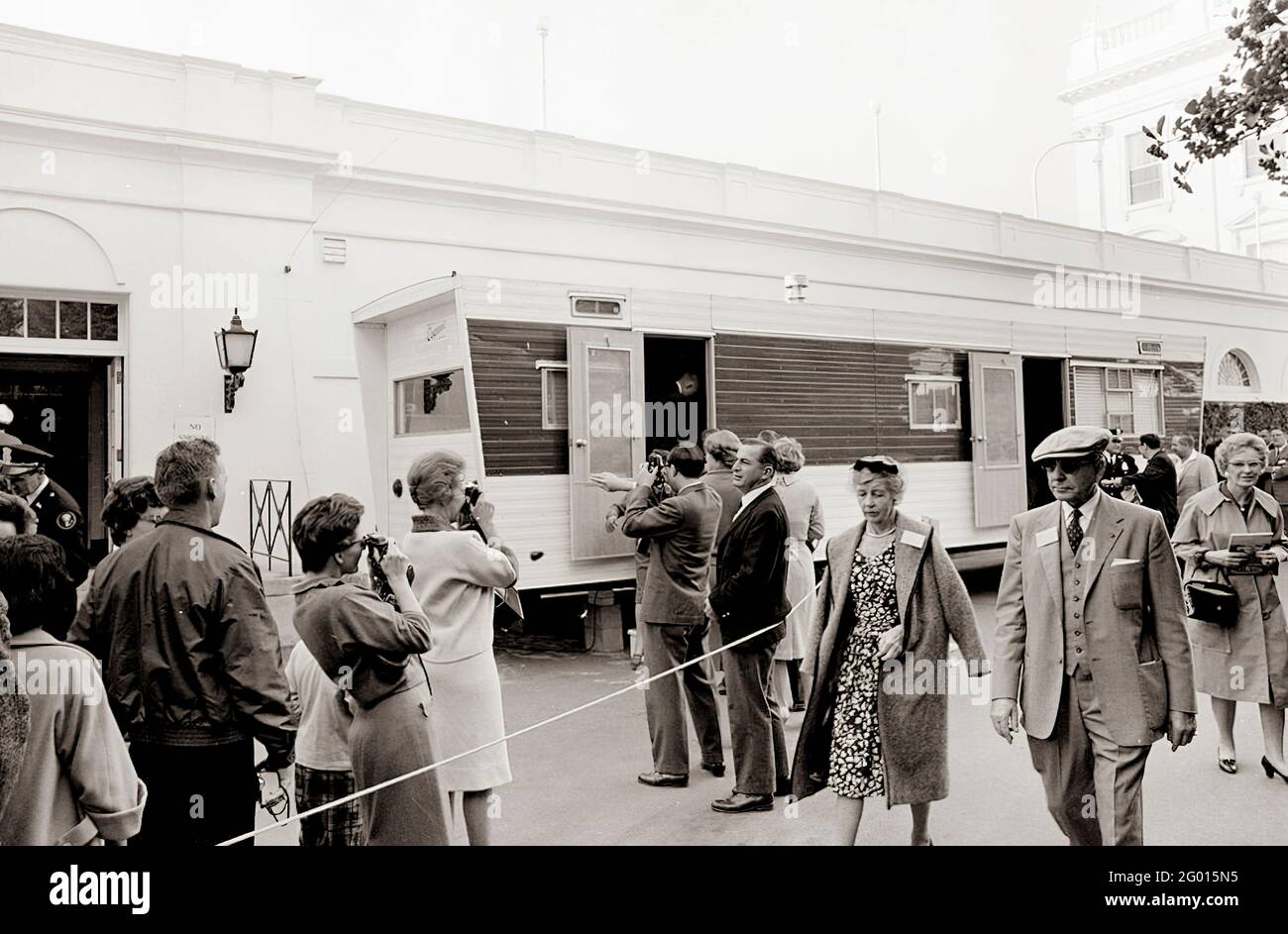 I visitatori aspettano in fila fuori da un rimorchio allestito vicino all'ingresso dell'ala est della Casa Bianca per lasciare le loro telecamere, borse e pacchi per l'ispezione, come parte delle nuove precauzioni di sicurezza stabilite in risposta alla crisi a Cuba. Washington, D.C. 23 ottobre 1962 Foto Stock