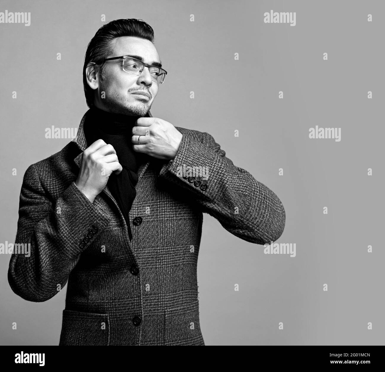 Ritratto in bianco e nero di uomo d'affari elegante in plaid a scacchi giacca e sciarpa nera che guardano lo spazio di copia Foto Stock
