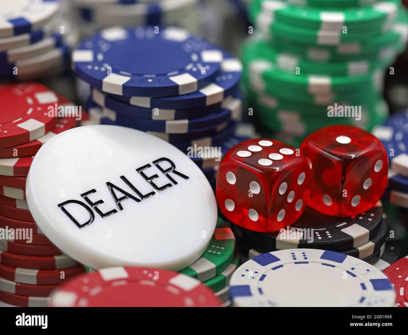 chip del dealer con morse rosse su chip di poker impilati, primo piano Foto Stock