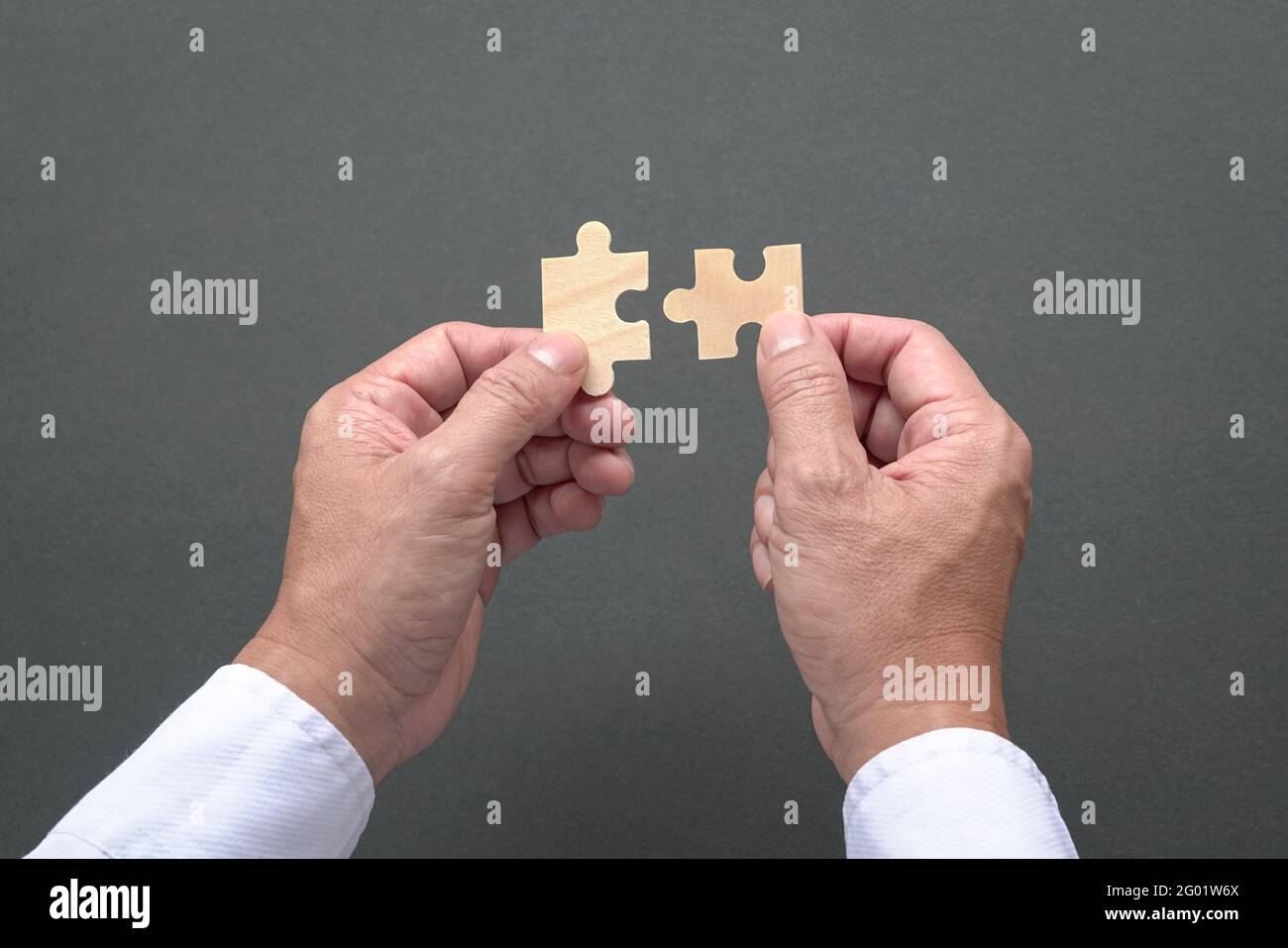 Due mani che tengono jigzaw puzzle, business matching, trovare il giusto concetto di misura. Foto Stock
