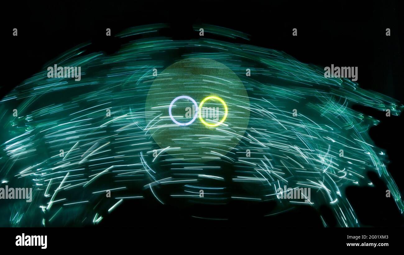 Cerchi chiari con striature verdi di luce su sfondo nero Foto Stock