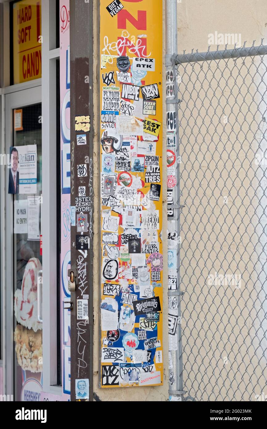 Collage contenente graffiti, adesivi, etichette e annunci pubblicitari su un negozio di Surf Avenue a Coney Island, Brooklyn, New York City. Foto Stock
