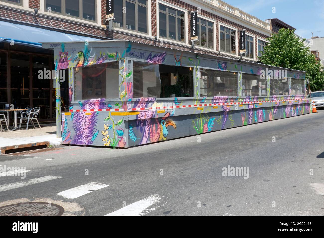Uno spazio artistico molto colorato per pranzare all'aperto all'Oliver's Astoria, un gastropub in Queens, New York City. Foto Stock