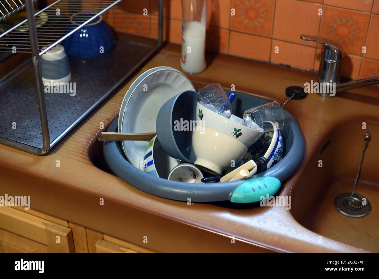 Il lavandino della cucina traboccante di stoviglie sporche, ciotole, piatti e lavatrice Foto Stock